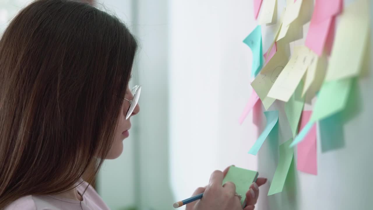 Stock Video Creative Woman Writing Ideas On Sticky Notes For Marketing Project Live Wallpaper For PC - Free Download