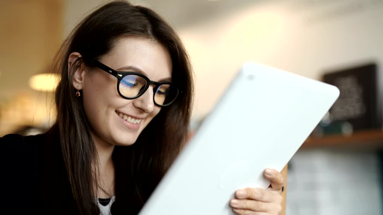 Free Video Stock Smiling Young Woman Surfs Internet On Tablet Live Wallpaper - Free Download