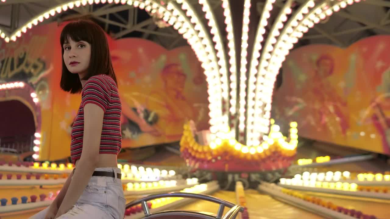 Free Video Stock teenage woman sitting in a mechanical fair game with the Live Wallpaper - Free Download