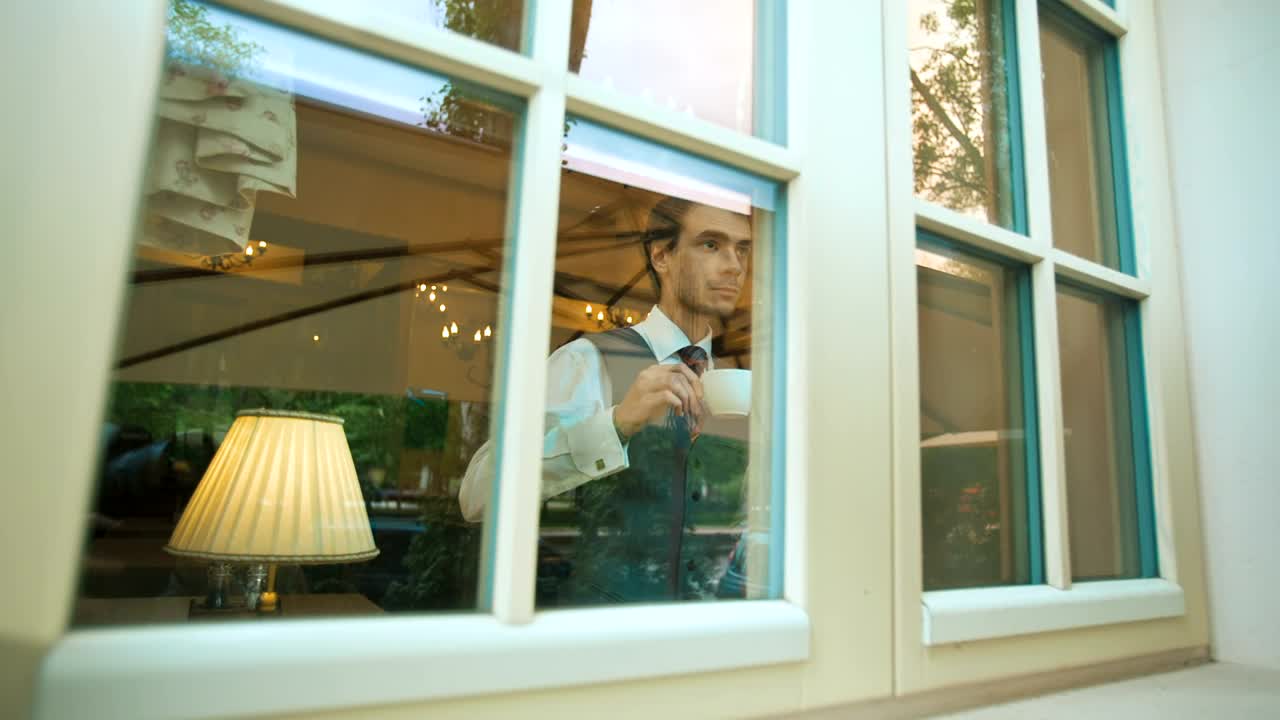 Stock Video Elegant Man Drinking From A Mug While Looking Out Live Wallpaper For PC - Free Download