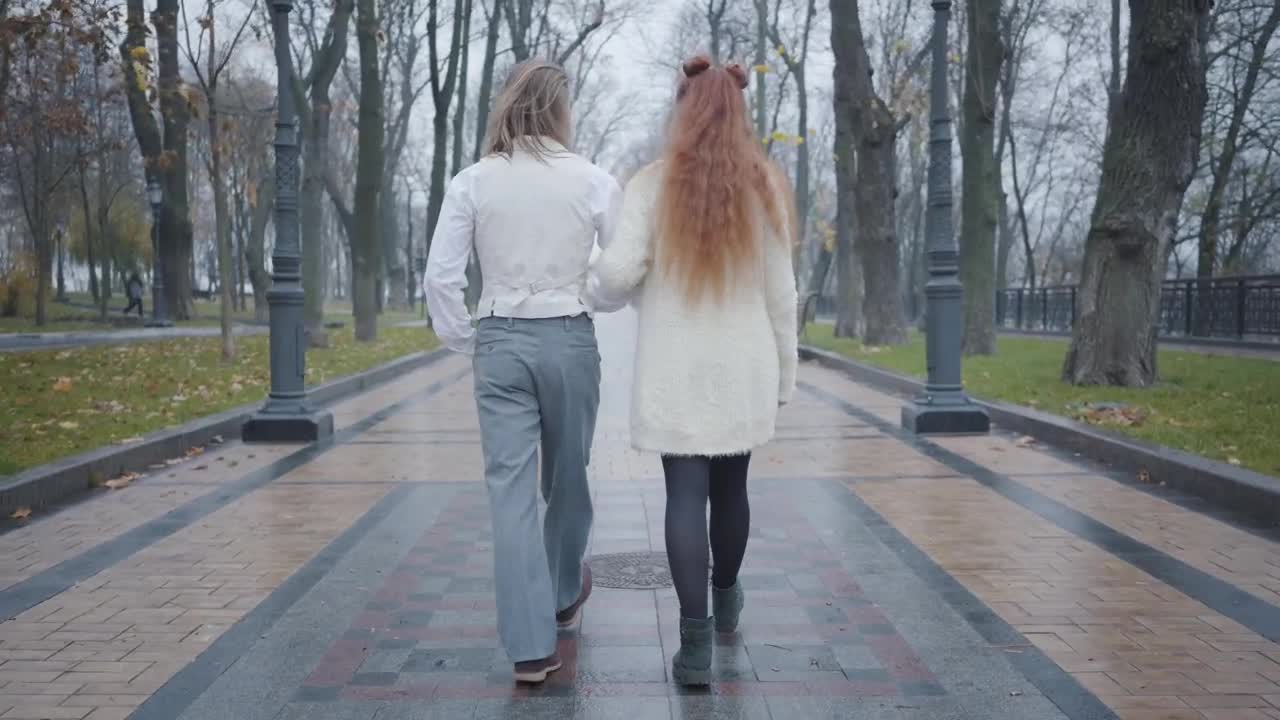 Video Stock Rear View Of Stylish Couple Walking In Rain Through Park Live Wallpaper Free - Free Download