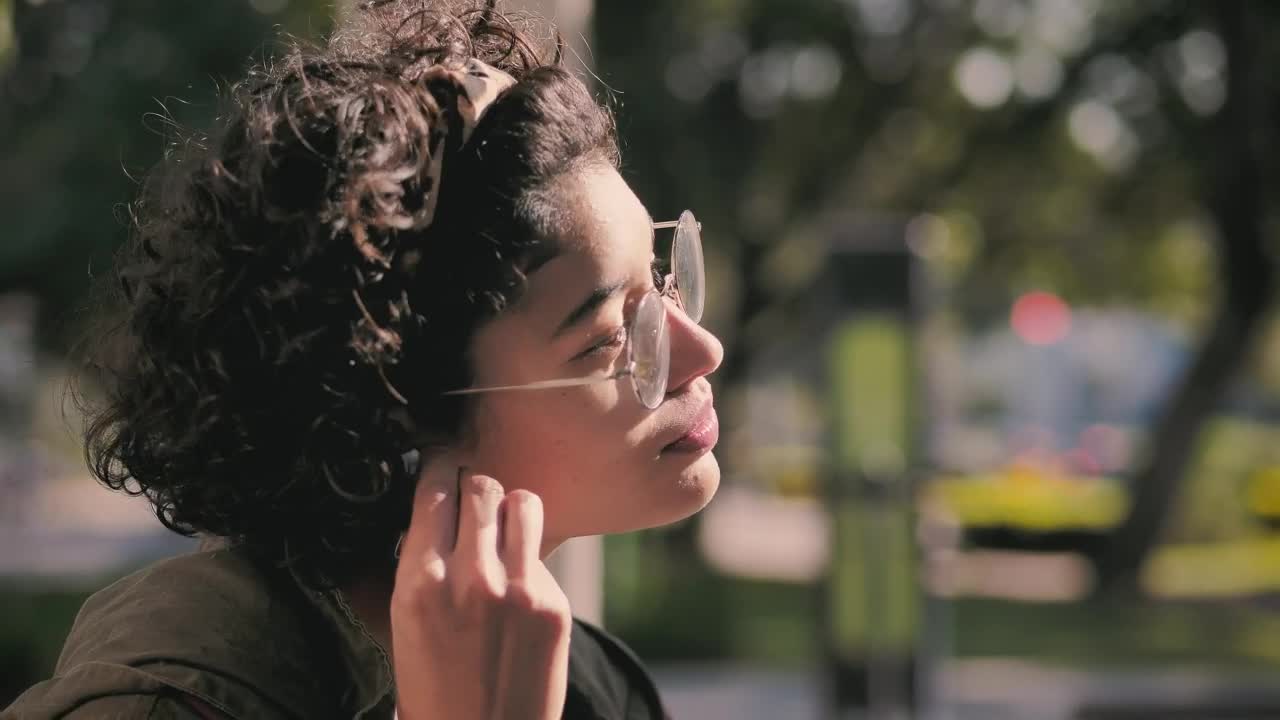 Free Video Stock teenager putting on headphones in the park Live Wallpaper - Free Download