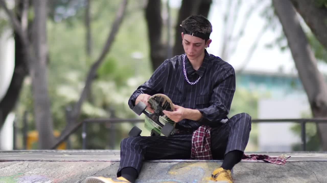Free Stock Video Young Skateboarder Sitting Placing His Skateboard Aside Live Wallpaper - Free Download