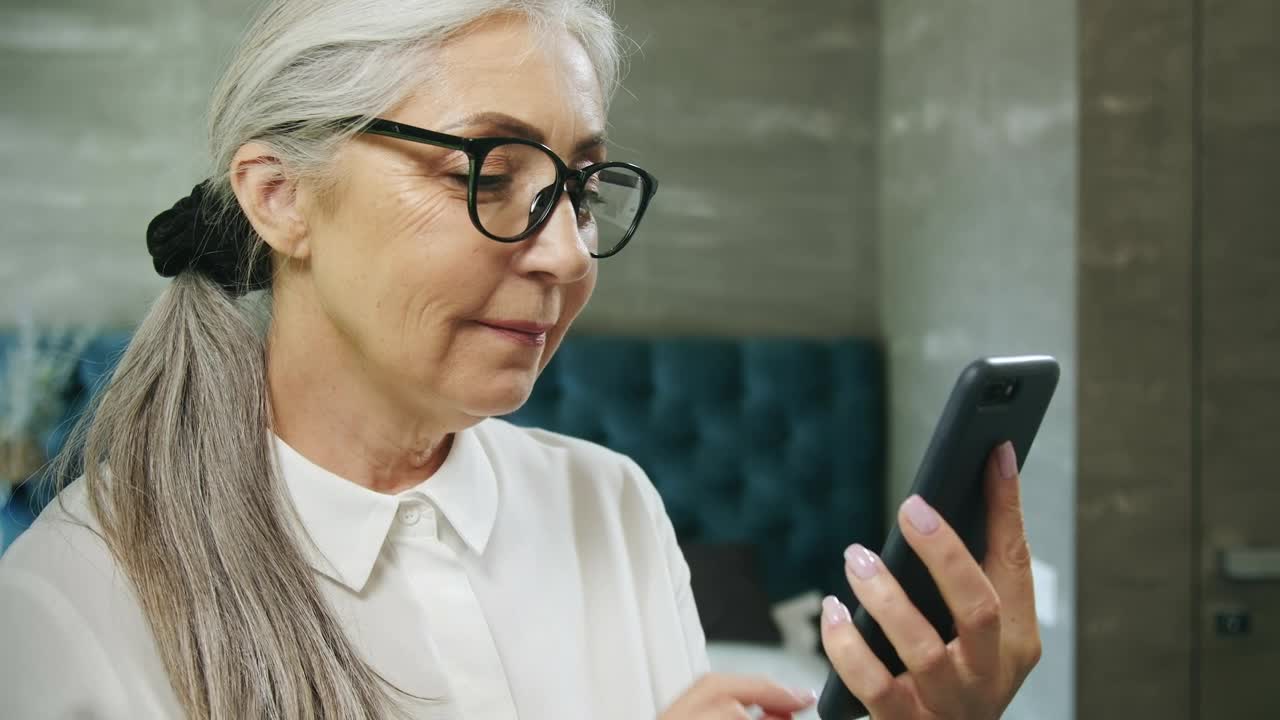 Stock Video Elderly Woman Texts On Mobile Phone And Smiles Live Wallpaper For PC - Free Download