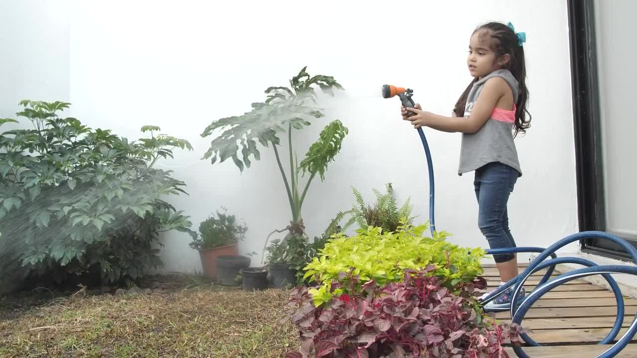 Stock Video Little Girl Watering Her Home Garden With A Hose Animated Wallpaper - Free Download