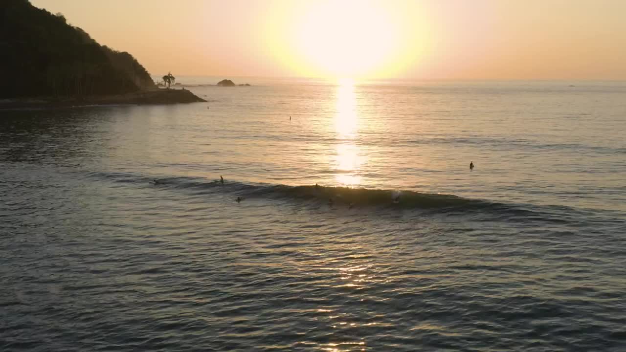 Free Video Stock surfing waves near a shoreline at sunset Live Wallpaper - Free Download