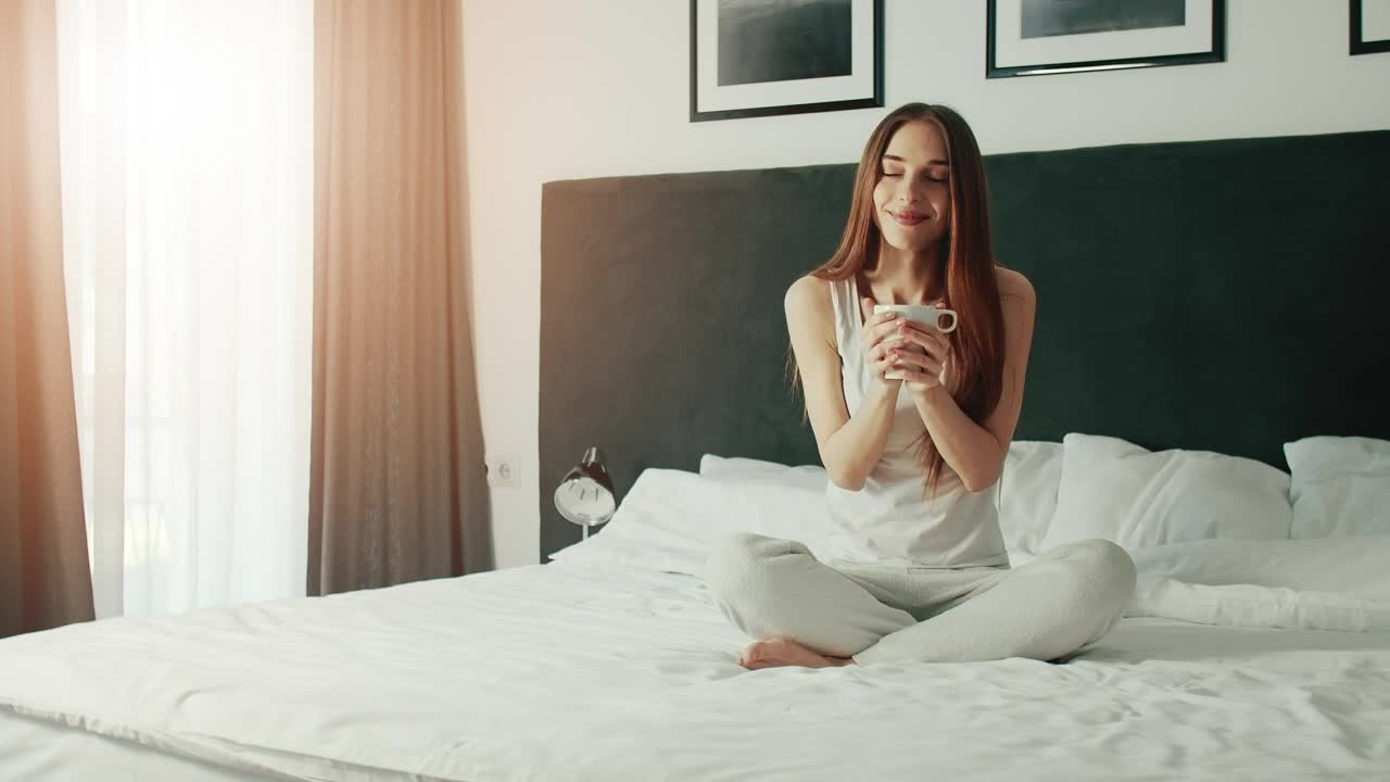 Free Video Stock Smiling Woman Enjoying Morning Coffee In Bed Live Wallpaper - Free Download