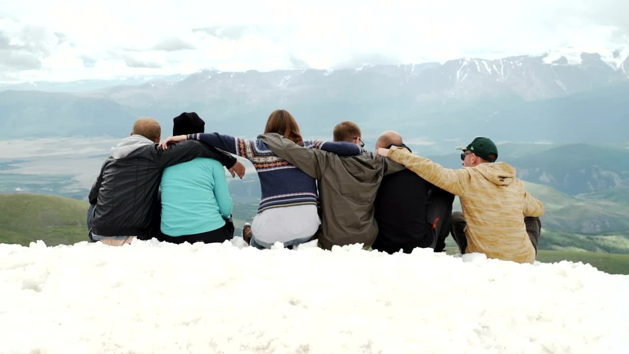 Stock Video Hugging Friends Look At Mountain Landscape From Snowy Ridge Animated Wallpaper - Free Download