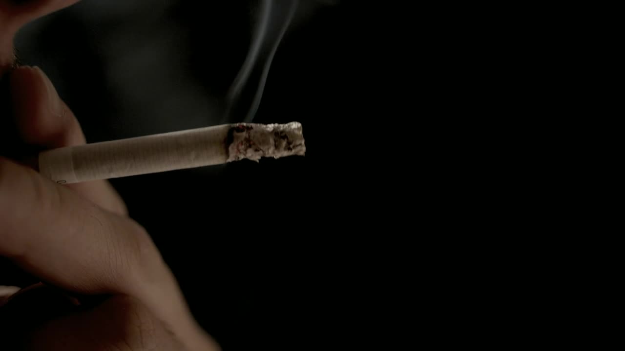 Stock Video Hand Holding Cigarette With Exhaled Smoke On Black Background Live Wallpaper For PC - Free Download