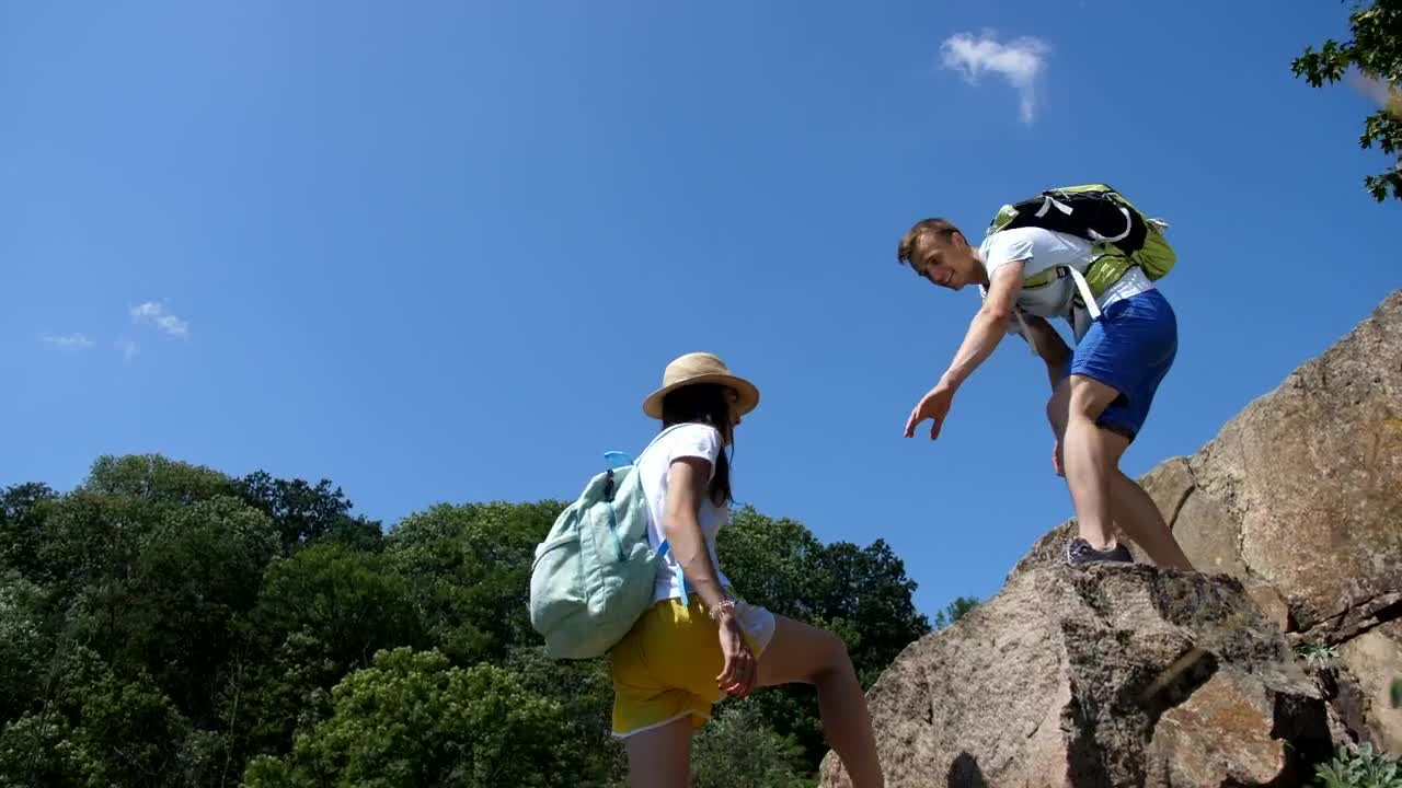 Stock Video Hiking Man Helping His Partner Climb Animated Wallpaper - Free Download