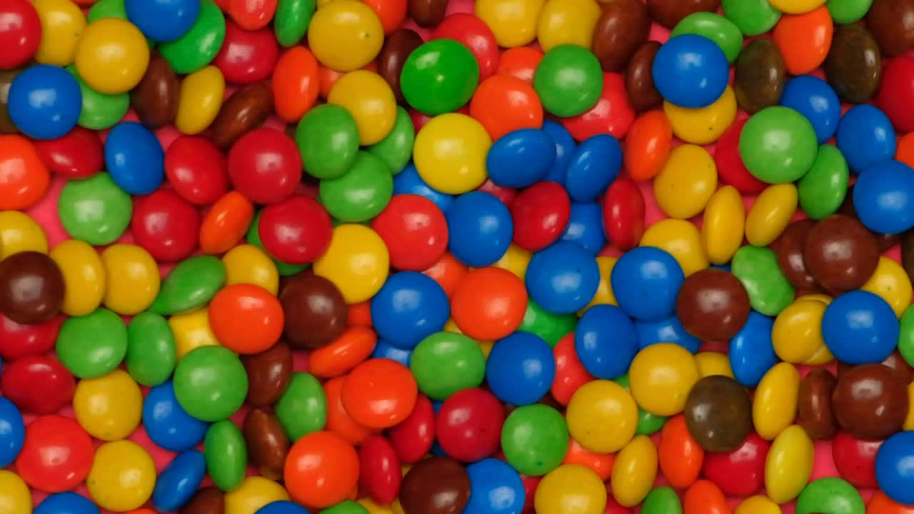 Stock Video Colored Chocolates Jumping On A Pink Background Live Wallpaper For PC - Free Download