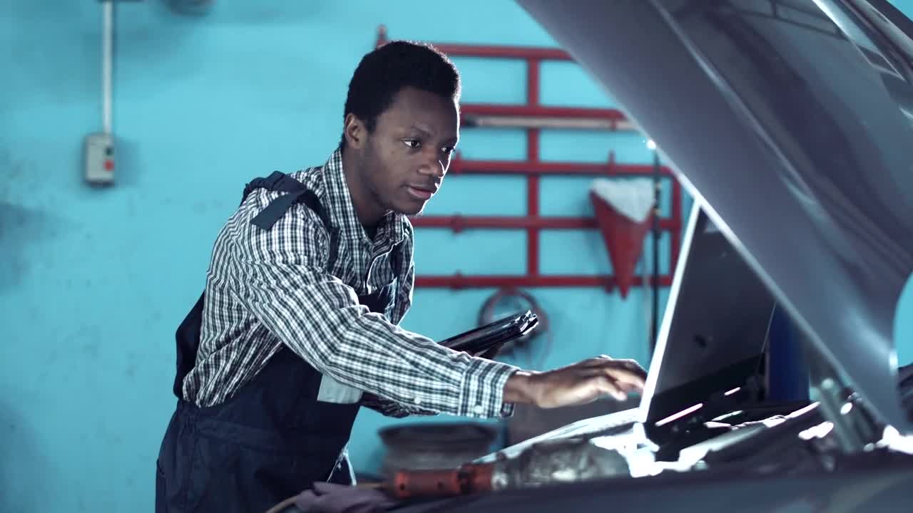 Stock Video Mechanic Checking A Car Motor With Compute Animated Wallpaper - Free Download