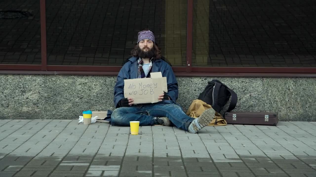 Stock Video Homeless With Cardboard Sign Sitting On The Street Animated Wallpaper - Free Download