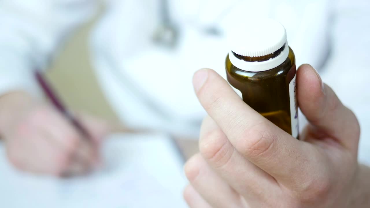 Stock Video Doctor Writing A Prescription Holding A Bottle Of Pills Live Wallpaper For PC - Free Download