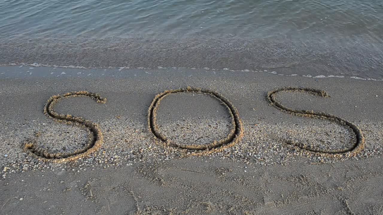Free Video Stock Sos Written In The Sand On The Shore Of A Live Wallpaper - Free Download