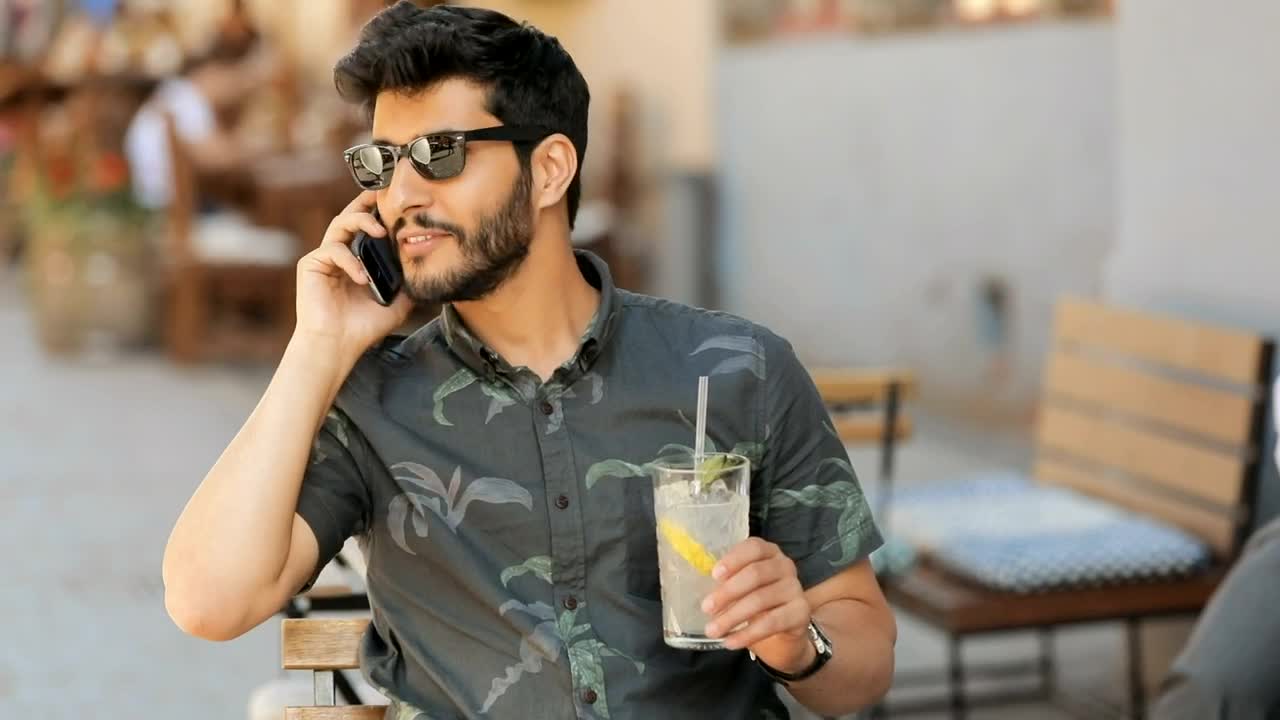 Stock Video Man In Sunglasses Talks On Mobile Holding Lemonad Animated Wallpaper - Free Download